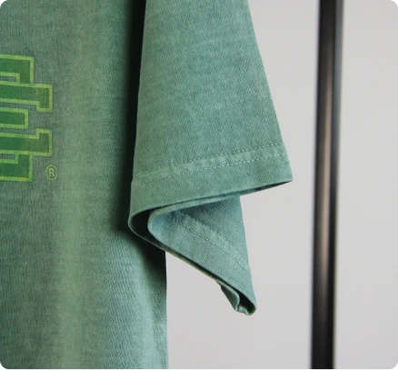 Detalhe da manga da t-shirt verde, evidenciando as costuras, presente no portefólio da Rotex