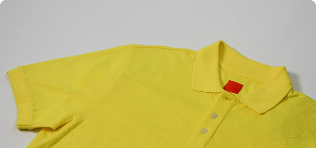 Close-up da gola e da manga de polo amarela, portefólio da Rotex.