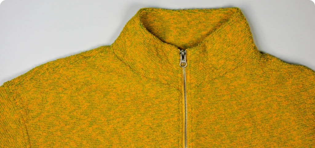 Close-up do casaco amarelo com fecho metálico, do portefólio da Rotex.