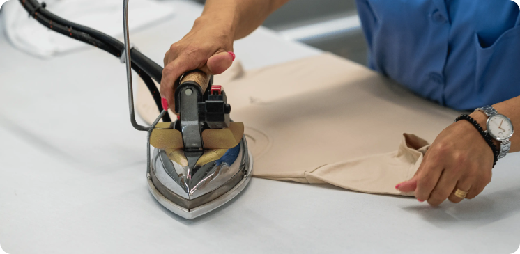 Pessoa a passar a ferro, representando o serviço de acabamento da Rotex.