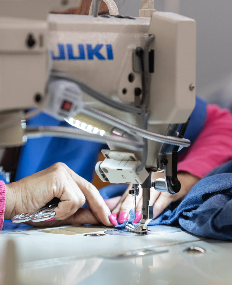 Detalhe de pessoa a costurar, representando o serviço de confeção da Rotex.